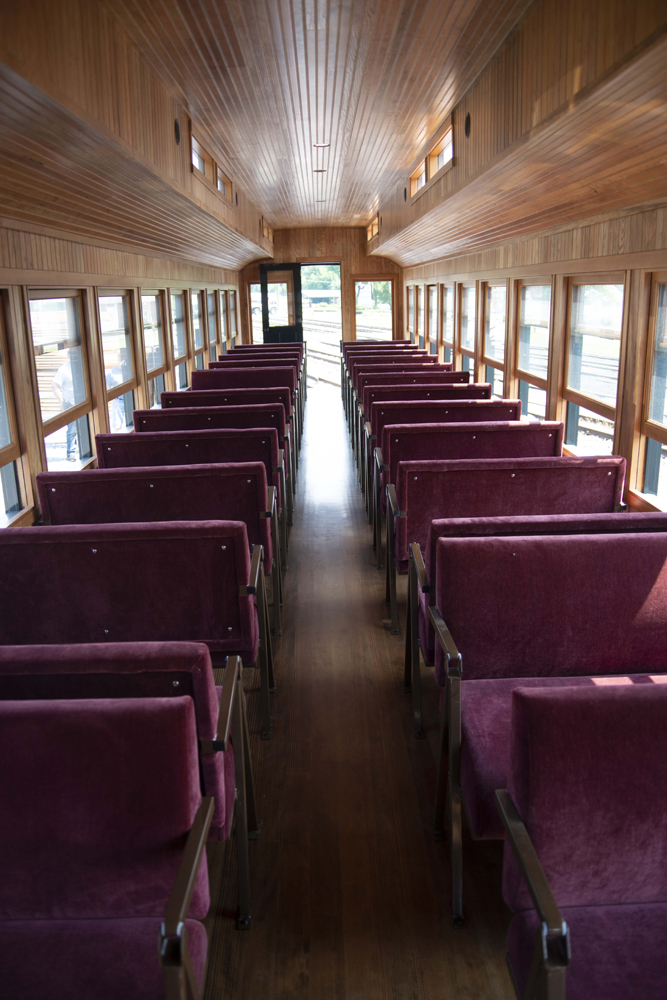 Interior of passenger car with red seats and wood paneling