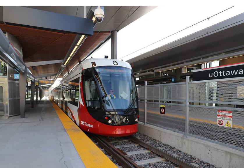 Red and white light rail trainset in station