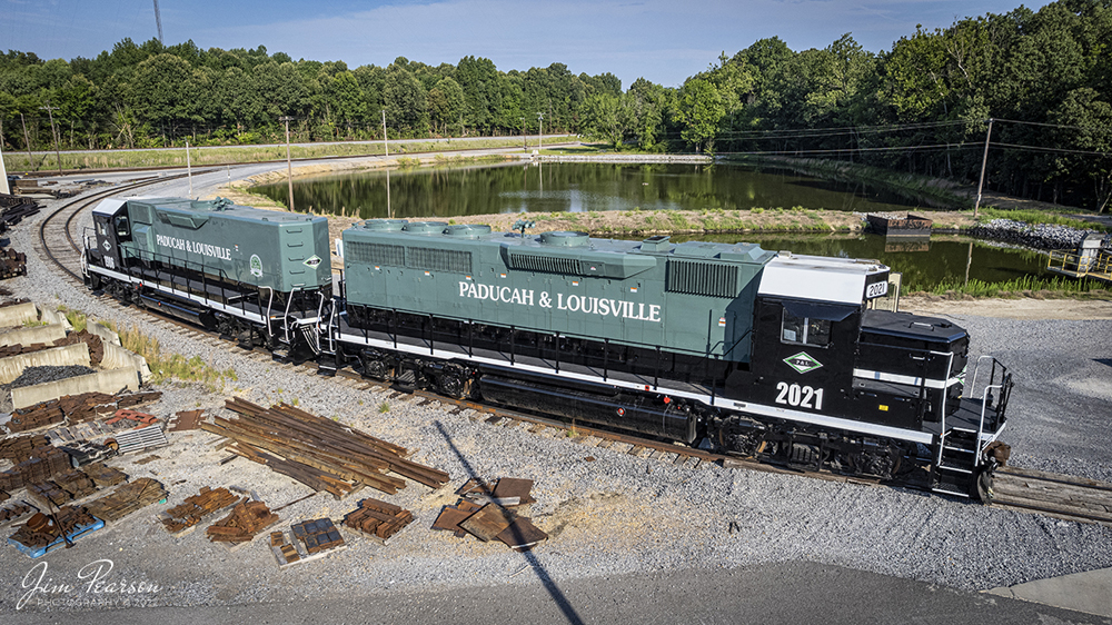 Two green and black locomotives with white trim and lettering