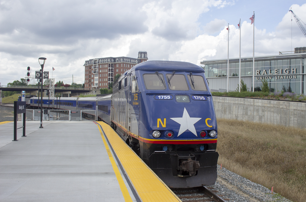 Blue locomotive with star on nose at passenger station