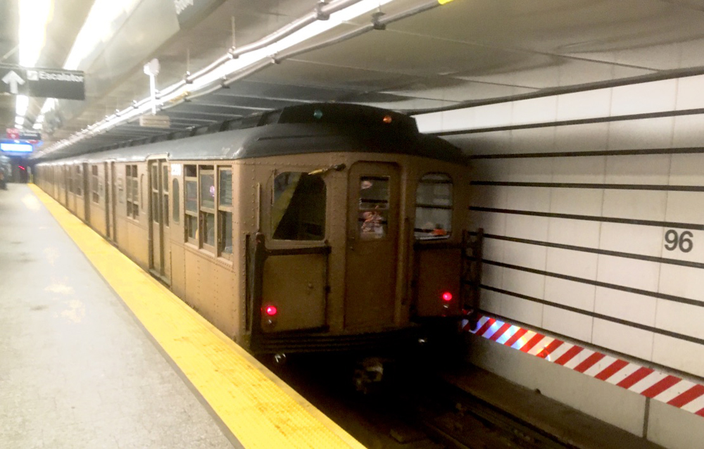 Brown subway cars moving through station