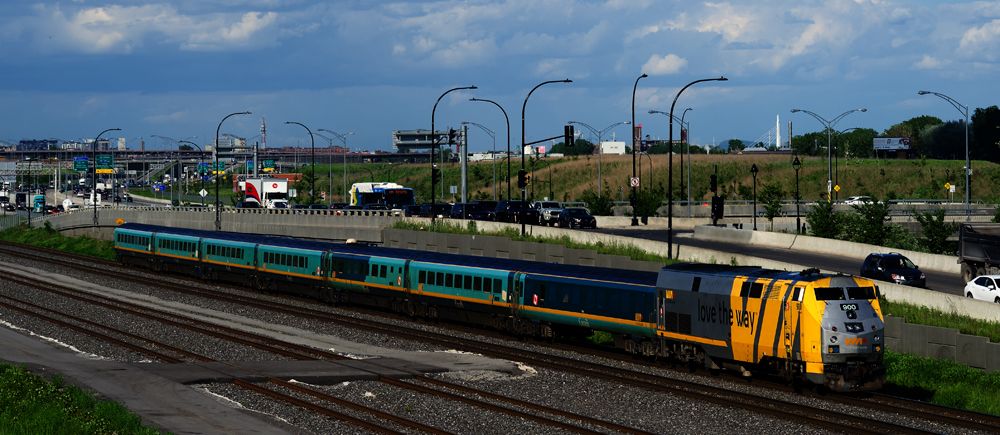 Yellow locomotive leads blue passenger cars