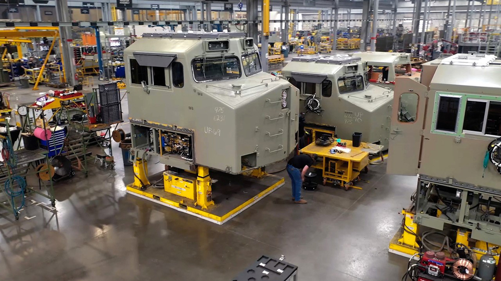 Locomotive cabs in primer paint on factory floor