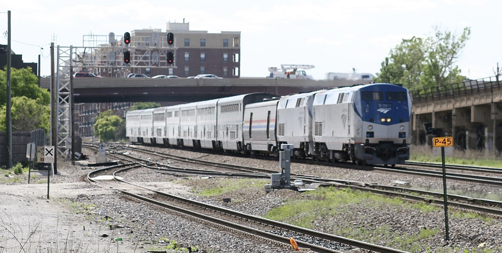 Passenger train in city with apartment building in background