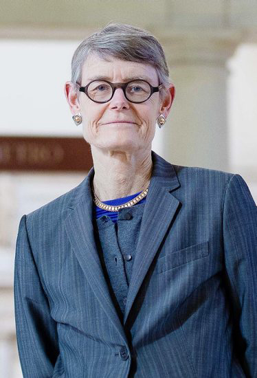 Woman with short hair and glasses in blue suit