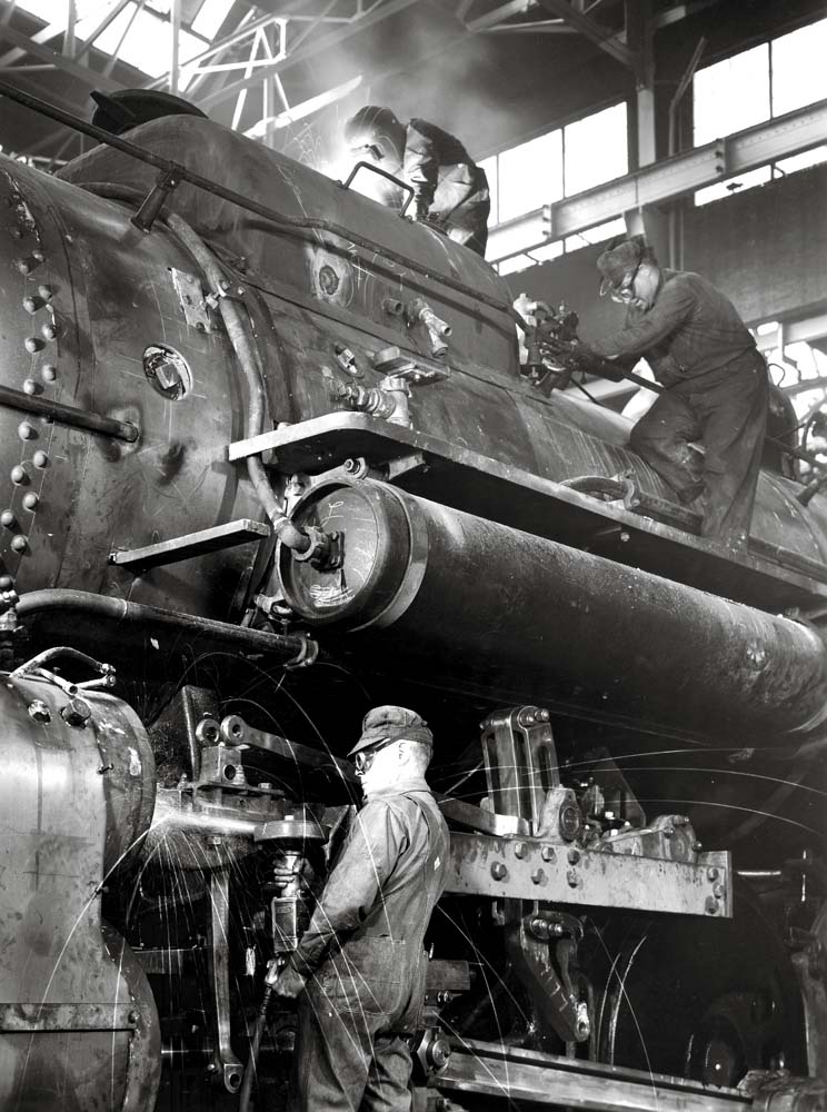 Men on a locomotive in a building, illustrative of railroad labor strikes