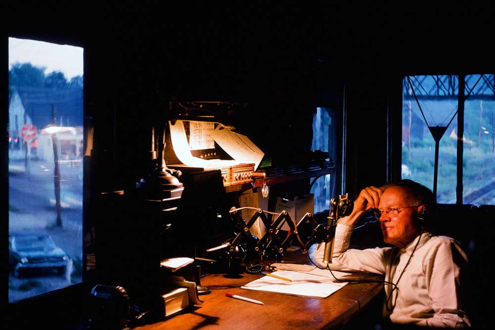 Railroad tower operator at desk in interlocking tower