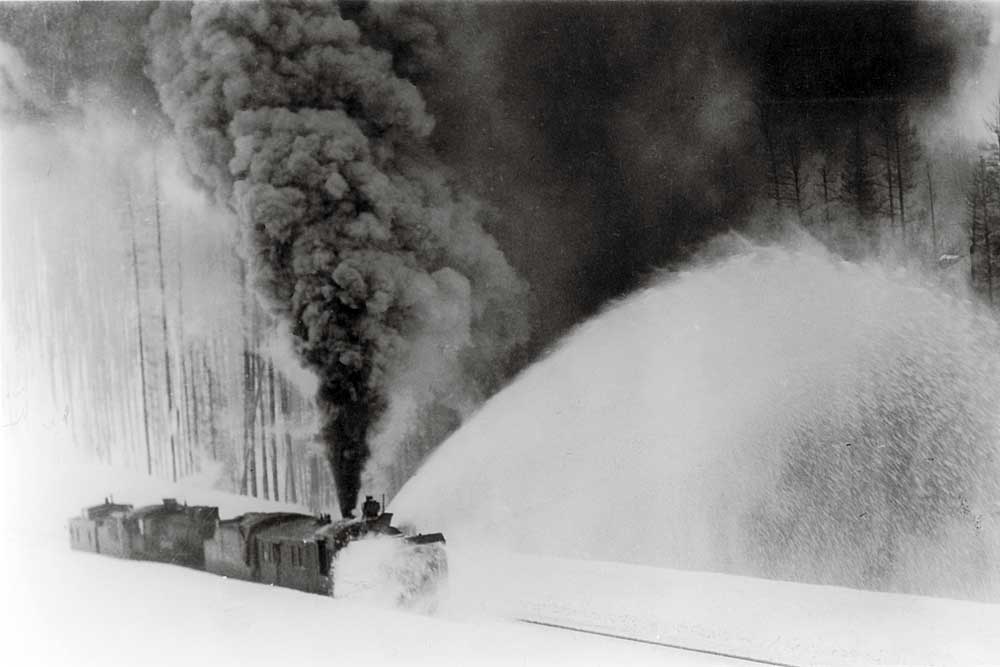 Smoking railroad equipment throwing snow from tracks