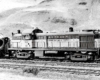 Four-axle diesel locomotive in front of hillside