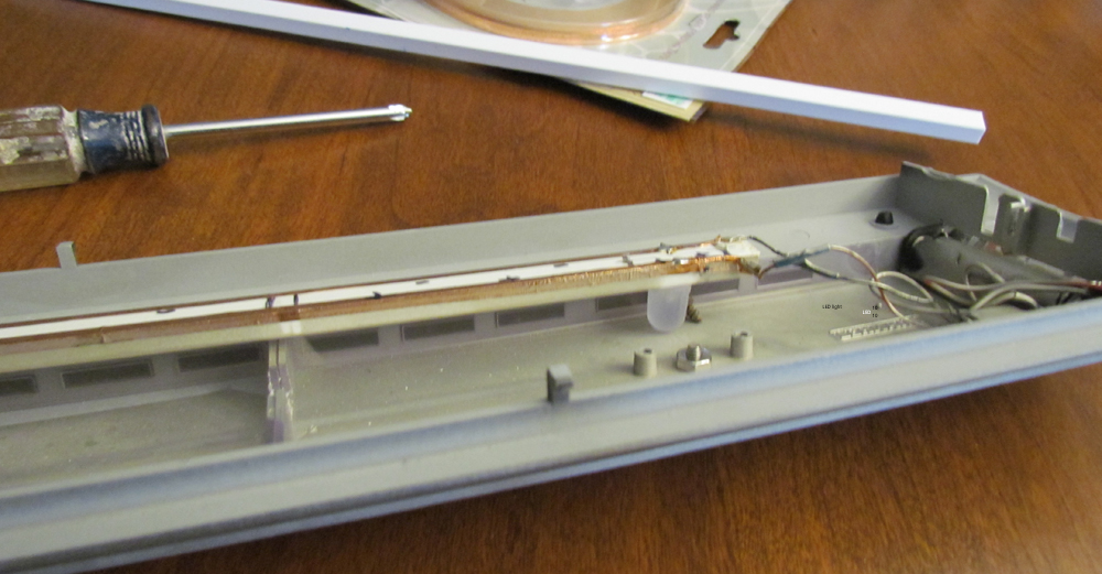 Tools and a plastic model passenger car roof on a workbench