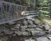 model train crosses bridge over river