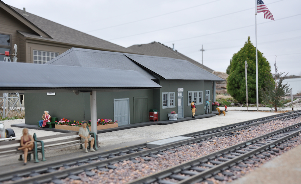gray model building in a garden railway