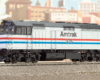 Photo of cowl-bodied locomotive in front of city backdrop