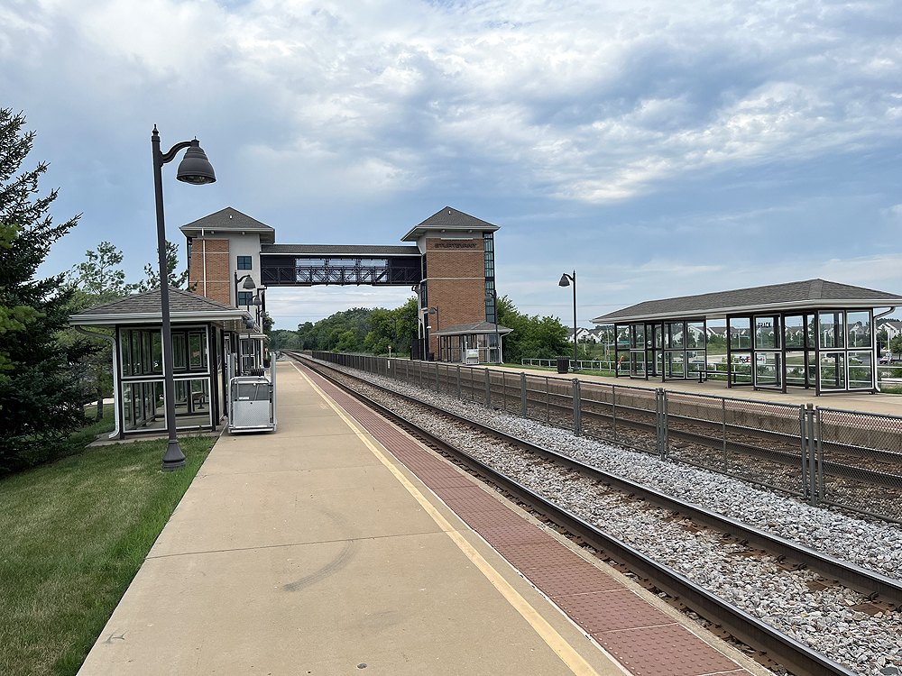 Metal and brick bridge over two railroad tracks.