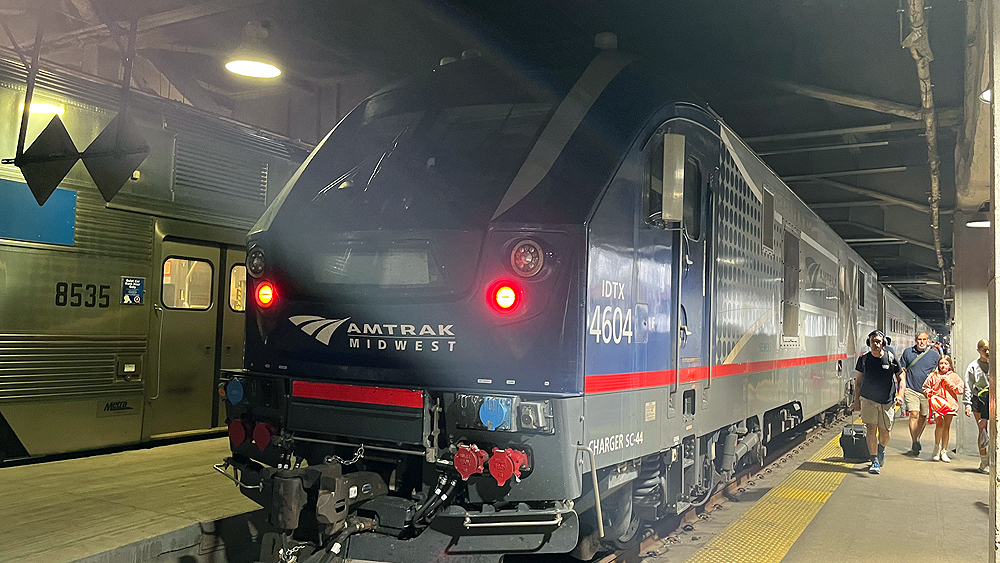 Amtrak locomotive and train at underground station platform.