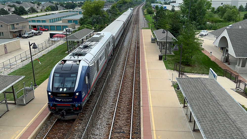 Overhead view of a passenger train arriving at an outdoor station