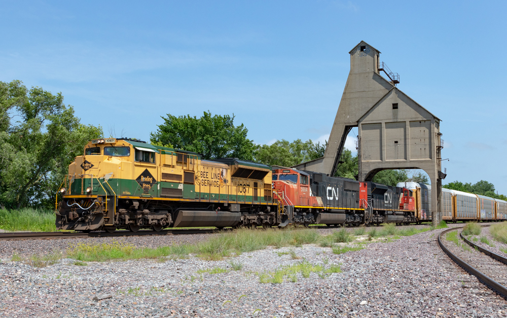 In service cab signals: A green-and-yellow locomotive leads a black-and-red locomotive on tracks.