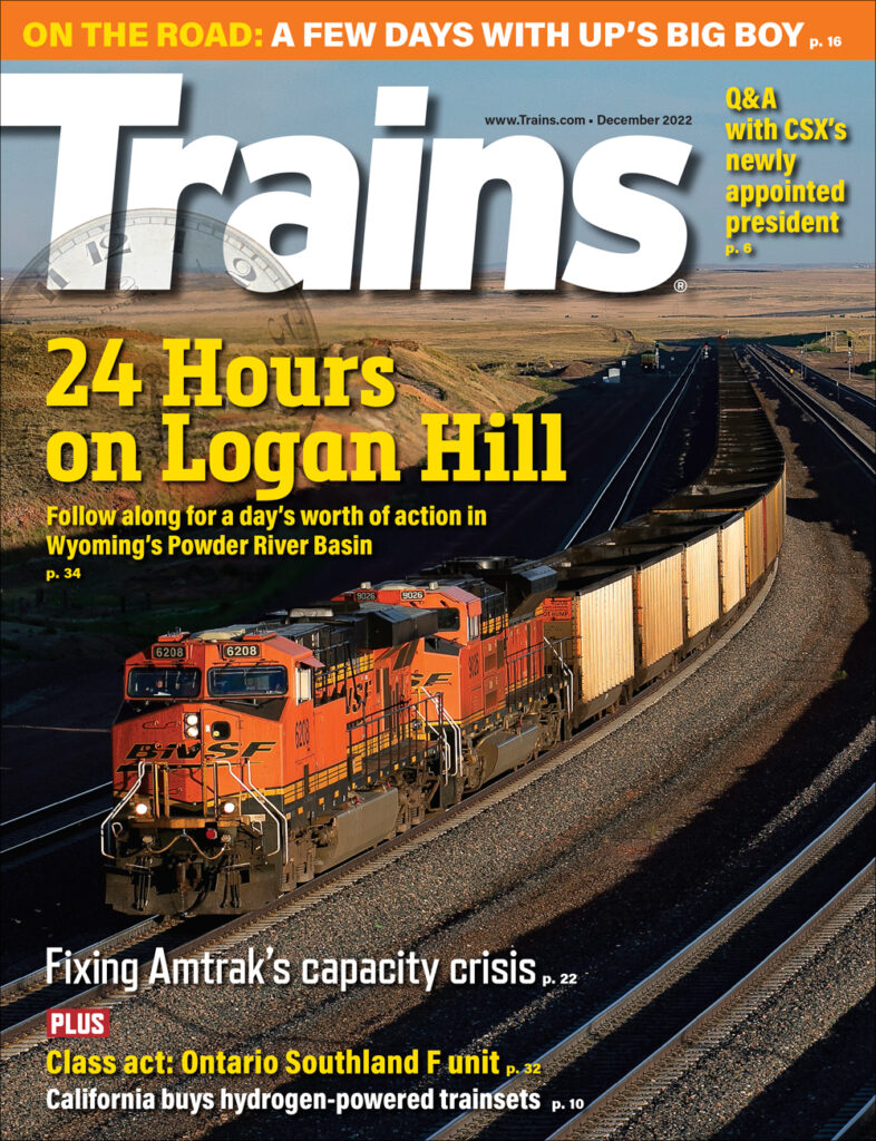 orange locomotive on railroad with sun