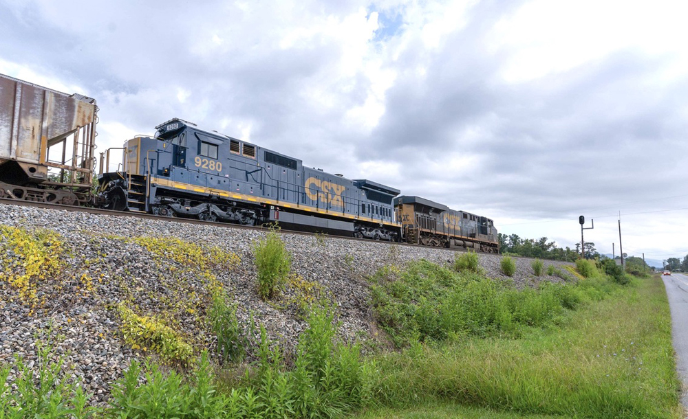 Blue standard-cab locomotive operating as second of two units on freight trainFre
