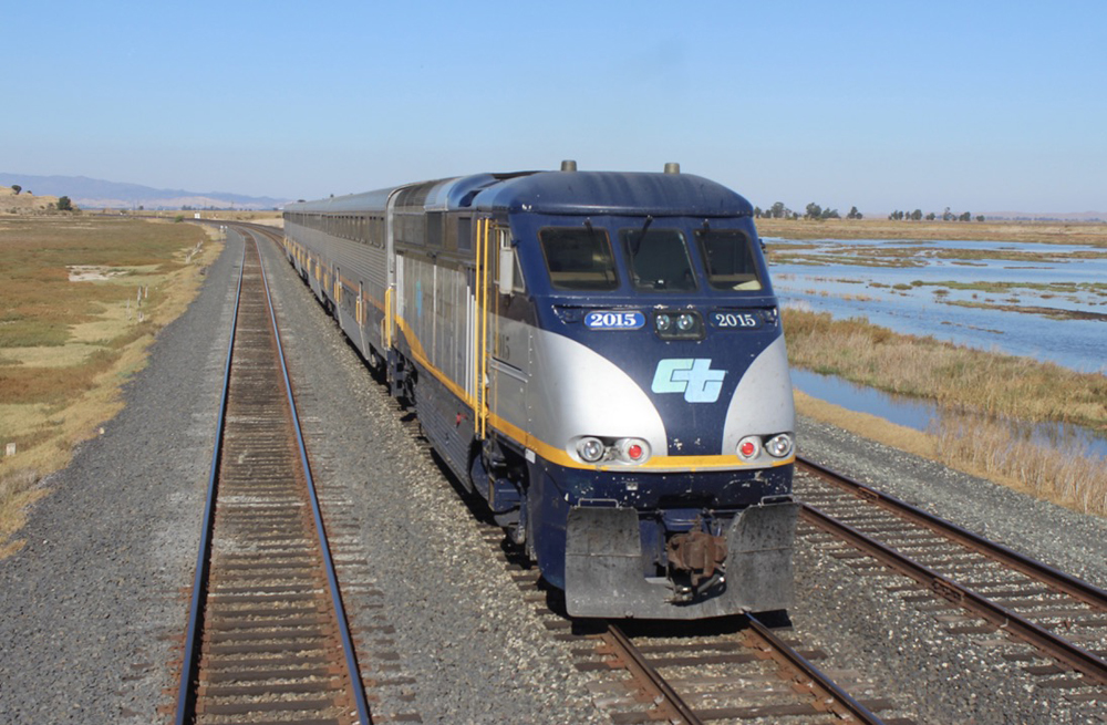 Passenger train on middle of three tracks, as seen from another train