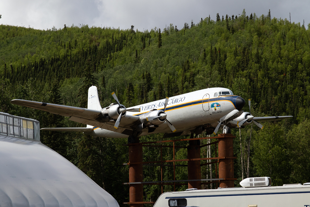 Airplane mounted on poles with mountains in background