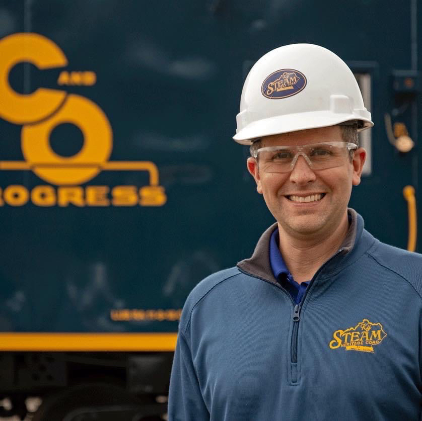 Man in hard hat in front of locomotive with C&O logo