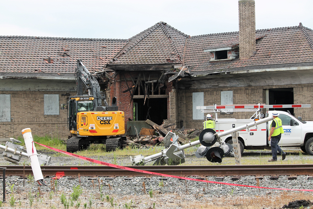 Heavy machinery knocking down brick building