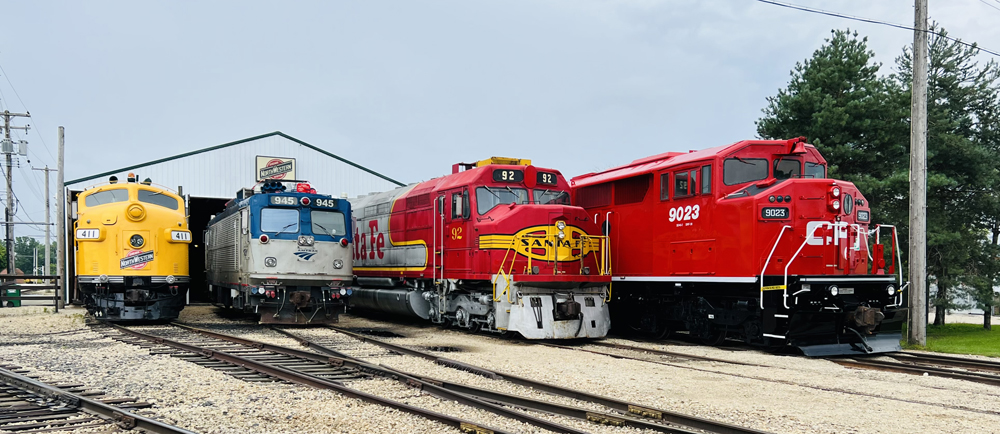 Four locomotives lined up outside shop building