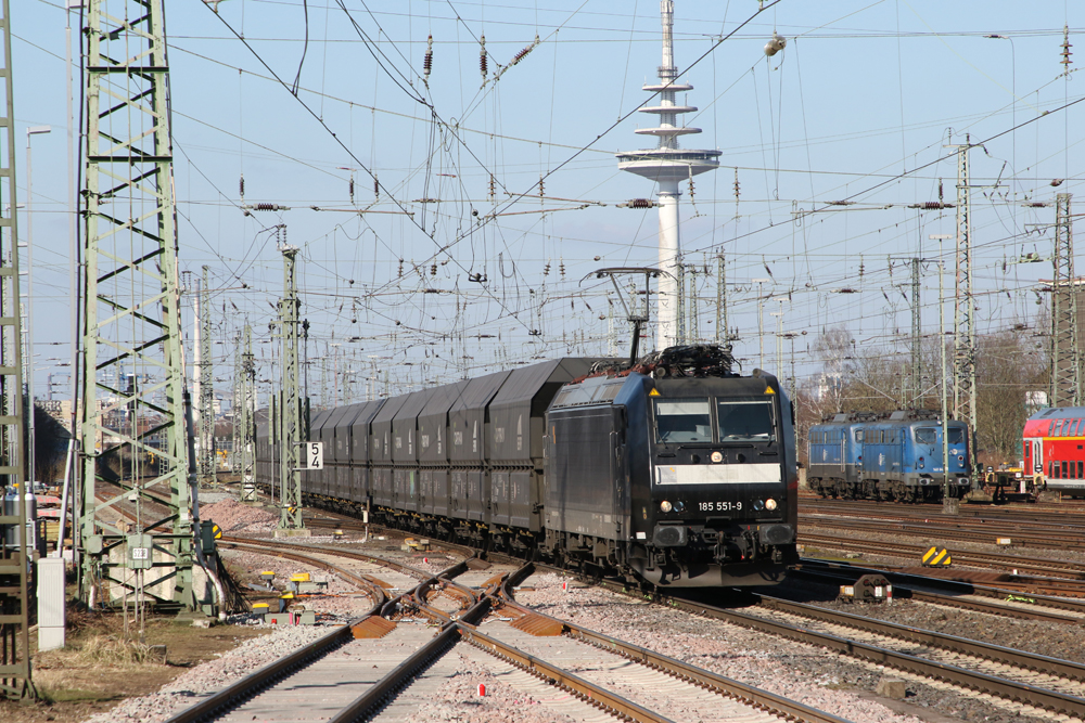 Black electric locomotive hauling unit train of black coal hoppers