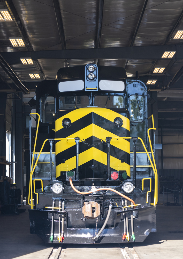 Front view of black locomotive with yellow stripes on nose
