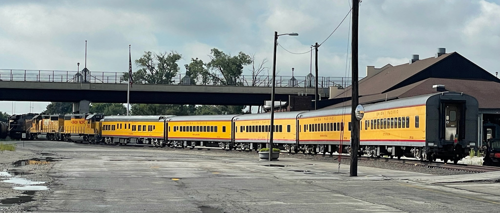 Yellow passenger cars moved by yellow freight locomotives
