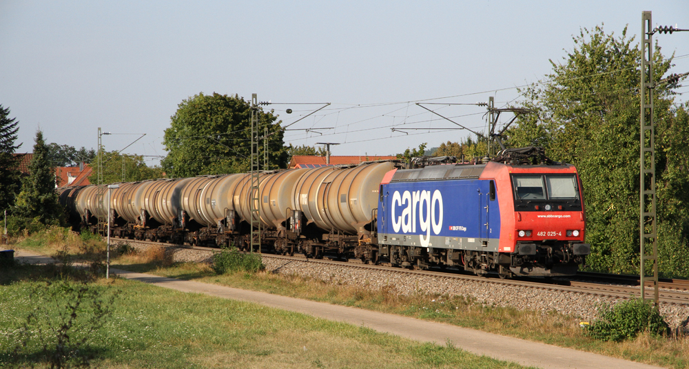 Red and blue locomotive with tank cars