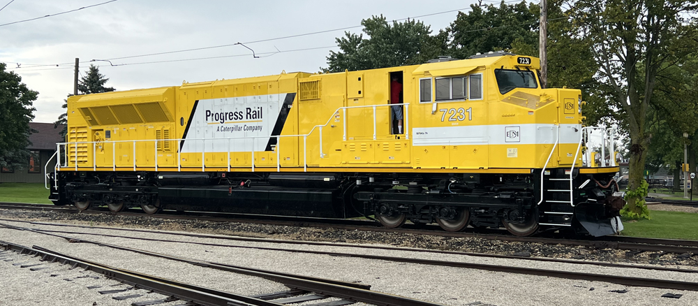Yellow and white locomotive with "Progress Rail" lettering