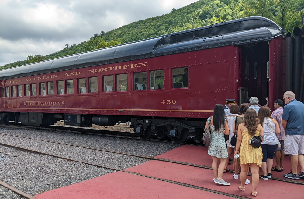 Passengers board Tuscan red heavyweight coach