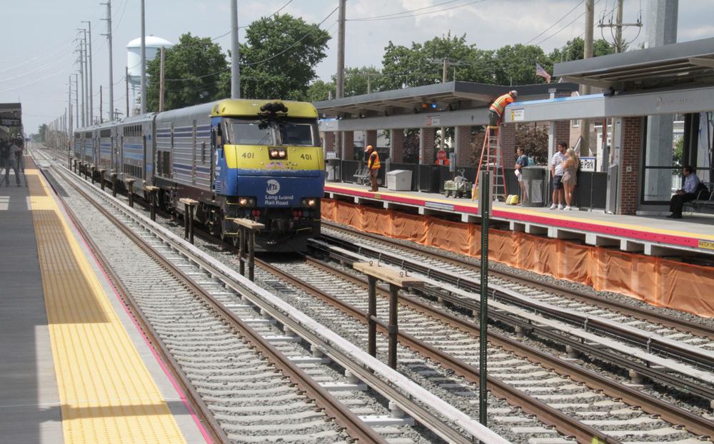 Train passes through station on center of three tracks
