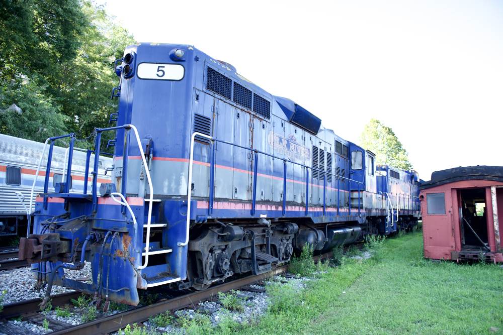 Blue road-switcher locomotive with gray and red trim