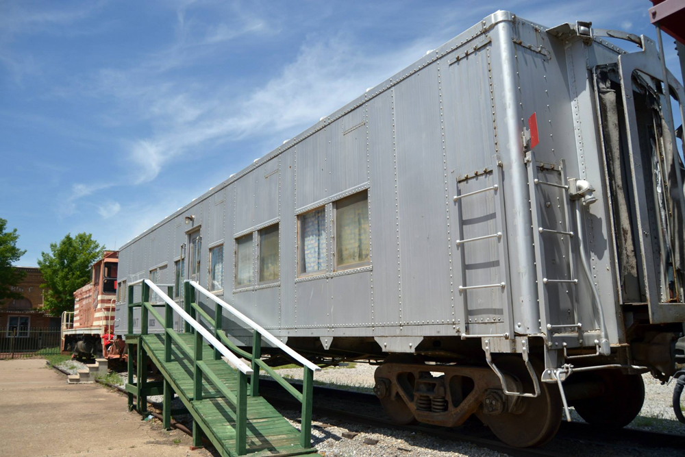 Silver troop sleeper attached to orange locomotive