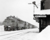 Freight train by station in snow with Bangor Aroostook locomotives