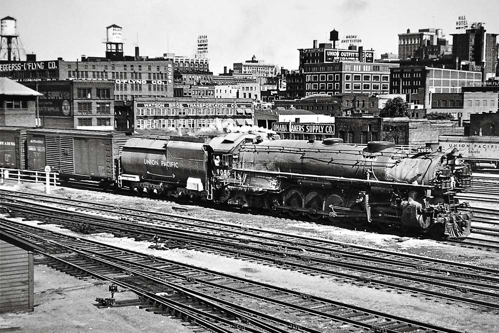 Steam locomotive with boxcars in urban scenery