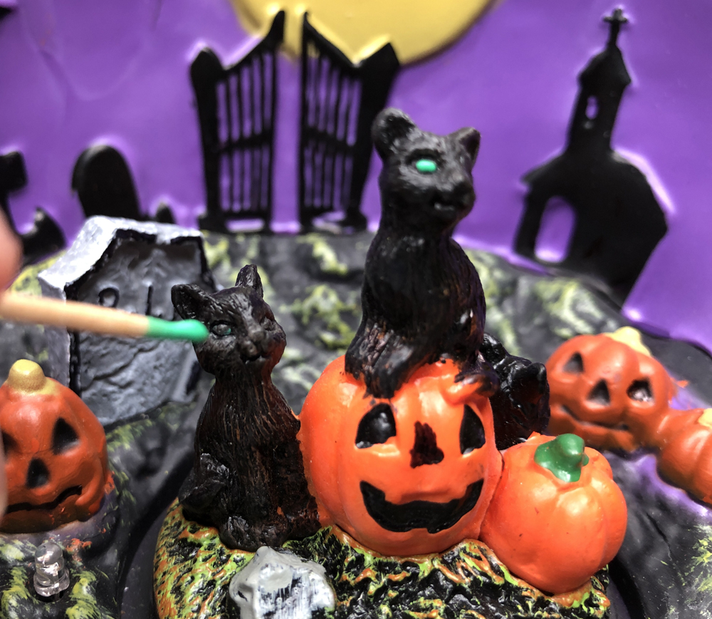 hand with toothpick painting cat eyes