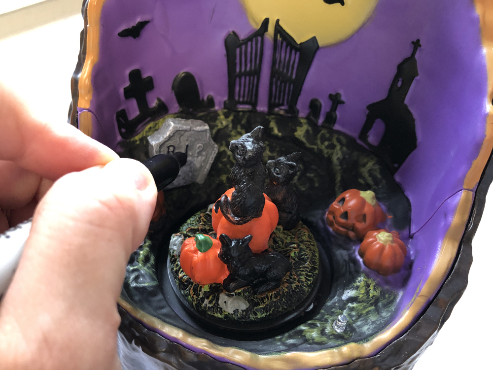 hand using marker to color on model tombstone