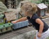 Girl reaches out to touch piece of model rolling stock