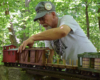 a man with a large-scale train on track