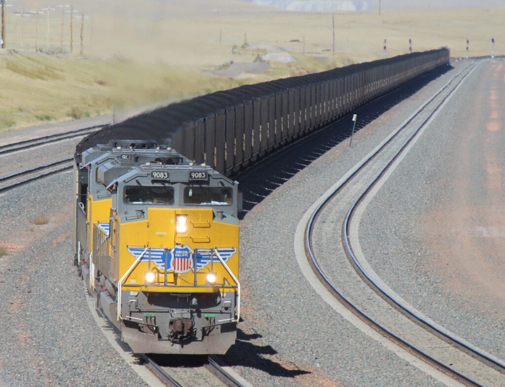 Yellow locomotives wtih coal hoppers