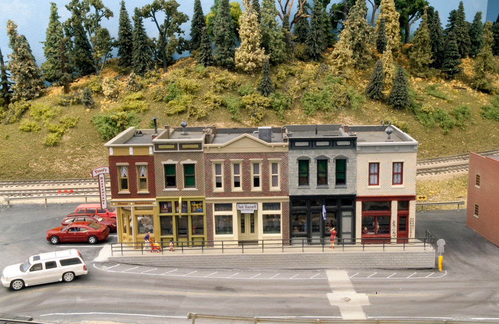 A street in front of a commercial block on the HO scale MR&T shows fading, wear, and patches