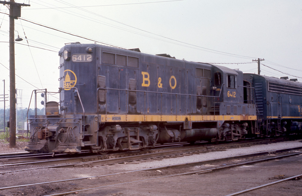 A blue-and-yellow Electro-Motive Division GP7 diesel locomotive is seen in 3/4 angle