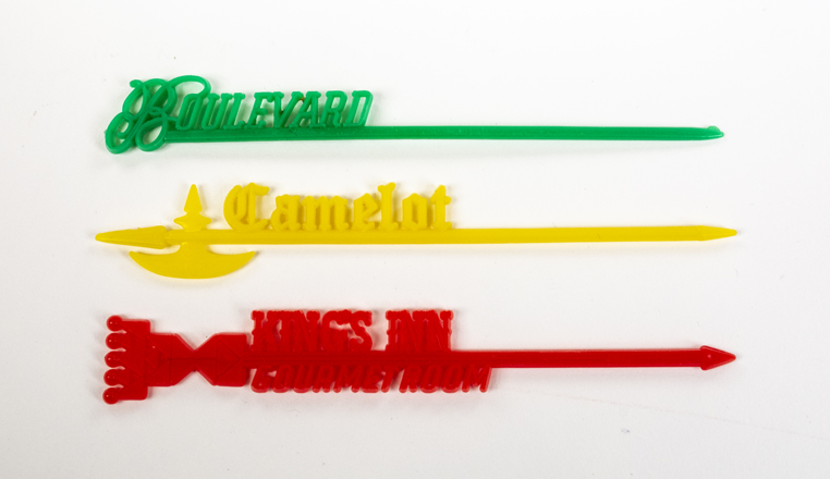 Red, yellow, and green swizzle sticks on a white background