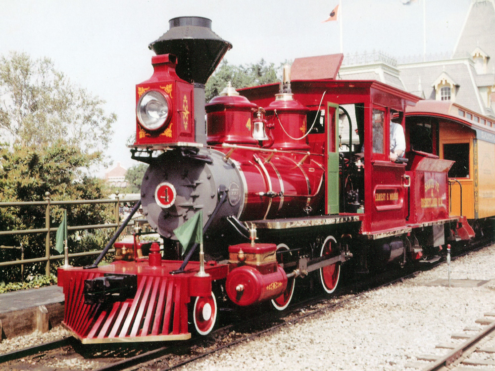 A shiny red steam locomotive is seen at Disneyland in California on a sunny day