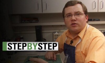 Man at a workbench with logo.