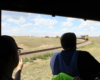 Fireman silhouetted in Big Boy cab window with diesel freight train waiting in background.